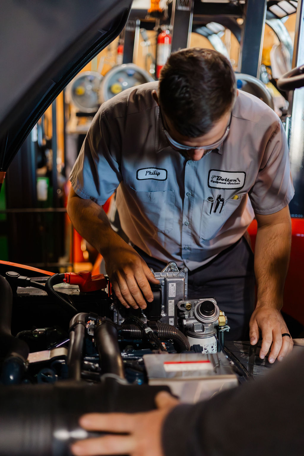 Bolton Equipment technician Philip working on a forklift engine in the Thibodaux shop